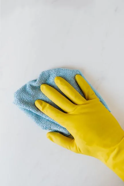 home-img Un homme nettoie une porte vitrée à l’intérieur à l’aide d’un vaporisateur et d’un chiffon.